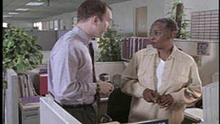 Two co-workers talking in a cubicle