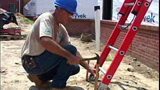 Working on a ladder safely while on uneven terrain