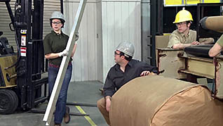 A group of workers in an industrial setting working and discussing creating a positive workplace in industrial settings