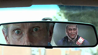A person in someones rear view mirror