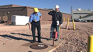 Two men inspecting a manhole cover