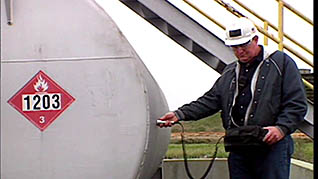 A man standing next to oil storage equipment