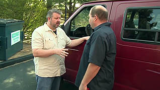 Two men talking outside of a large vehicle