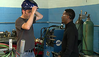Two men putting PPE on