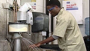 An auto worker washes his hands in the mechanic safety training video