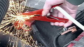 A man improperly using jumper cables