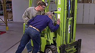 Two men inspecting a forklift