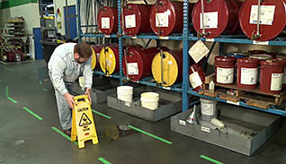 Man putting up a wet floor sign