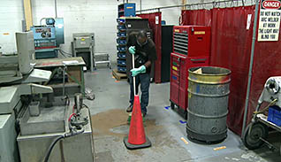 Man mopping next to a cone