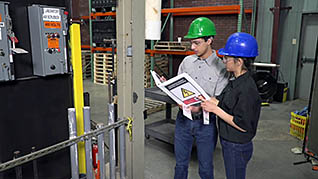 Two employees reading a manual