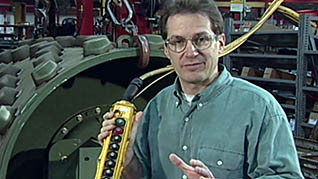 A man explaining the buttons on an overhead crane