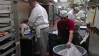 Two men cleaning the kitchen