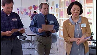 Three people standing in a classroom