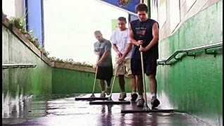 Three guys cleaning a hallway