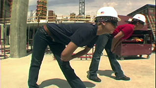 Two construction workers stretching