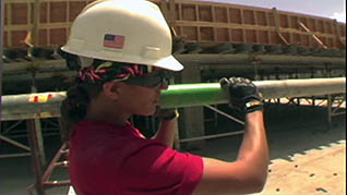 A worker carrying equipment in the stretching for construction workers training video