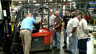A man explaining forklift safety to co-workers