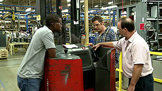 Three men discussing forklift safety