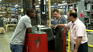 Three men discussing forklift safety