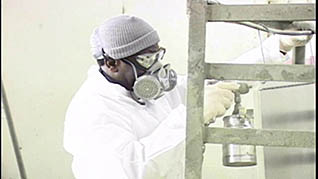 A man wearing a gas mask using hexavalent chromium