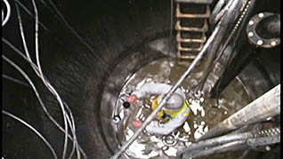 Multiple workers checking a confined space for entry