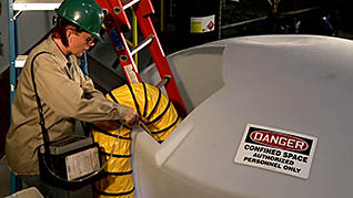 A man putting a tube into a confined space