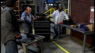 Three men in a warehouse