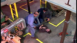 Two men helping a co-worker who got hurt