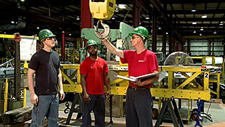 Man teaching two other men how to safely operate an industrial crane winch