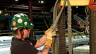 Woman inspecting the belts of an industrial crane