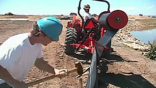 A man hammering stakes into the ground