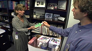 A woman hands a man hand sanatizer as part of pandemic preparedness