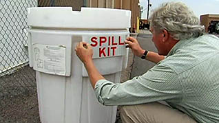 A man labeling a spill kit