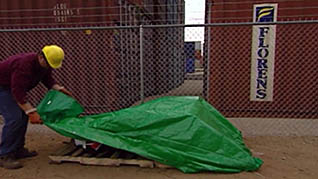 A man protecting equipment from storm water