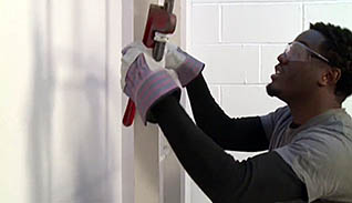 A man wearing safety glasses measures a wall for an accident investigation case study