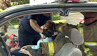 First responders attending to a victim of a car accident