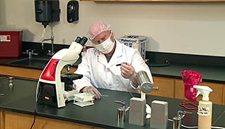 A man wearing proper PPE in a lab