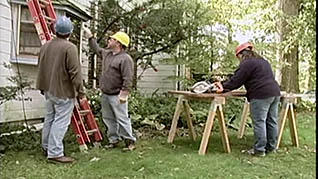 Three men doing work on a house