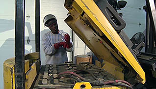A man fixing a forklift engine