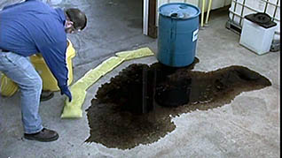 A man taking the proper steps to cleaning up a hazardous spill