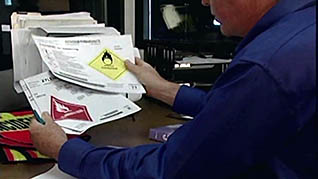 A man reading documents about hazardous chemicals