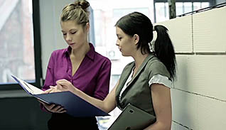 Two women reading medical files