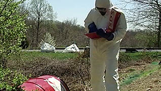 A man handeling a barrel of hazardous materials