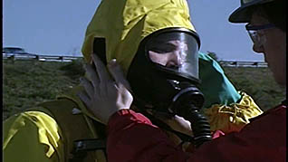 A man wearing a hazmat suit to clean up a spill