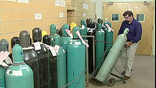 A man safely stores a gas cylinder in a laboratory