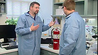 A man showing an employee where the fire extinguisher is