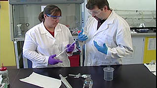 Two workers properly using glassware to prevent any accidents