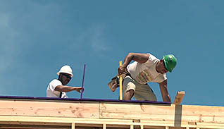 Two men building a roof