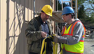 Two men looking at a safety harness