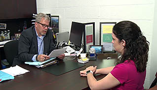 Man talking to a woman at a desk